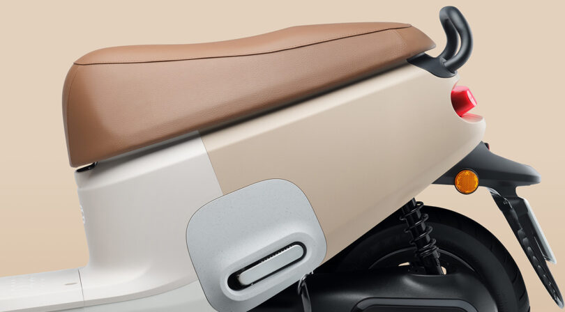 Detail of Muji Gogoro Smartscooter's seat and taillight in white and beige colors.