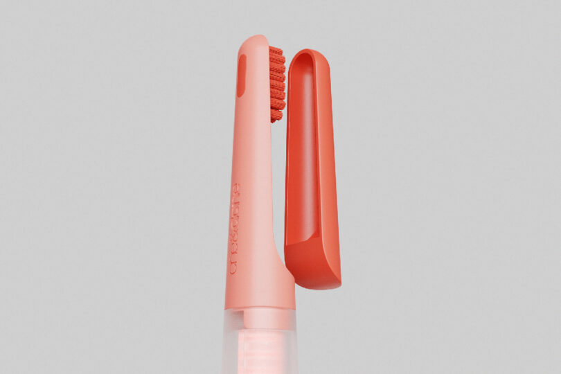 Detail of one&done logo across the toothbrush head holder in coral finish.