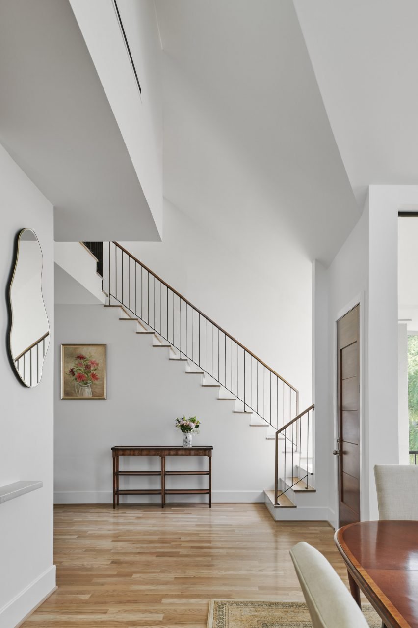 White double-height entrance hallway in a Houston home by O'Neill McVoy Architects