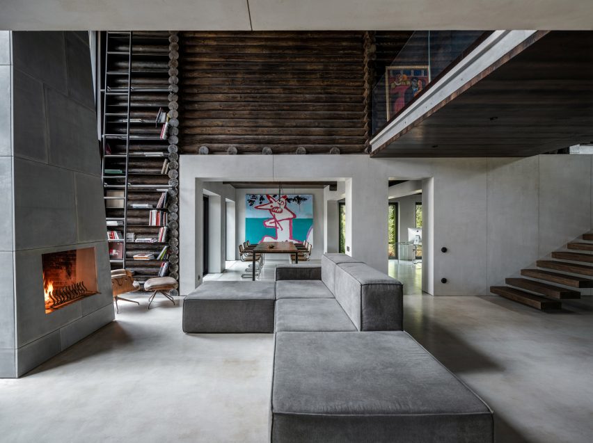 Photograph showing large sofa in living area looking into dining area