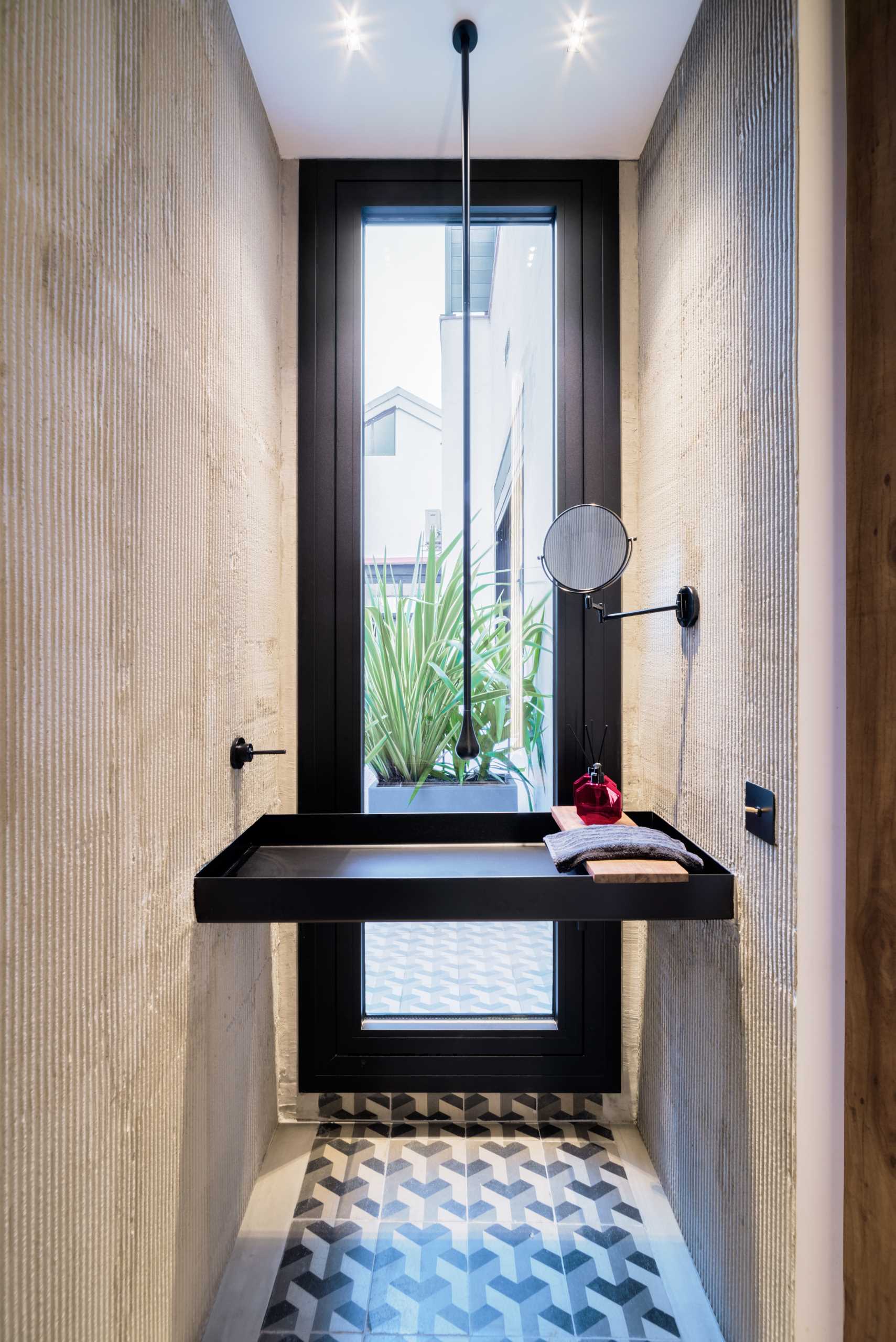 In this bathroom, a minimalist vanity spans the distance between the walls.