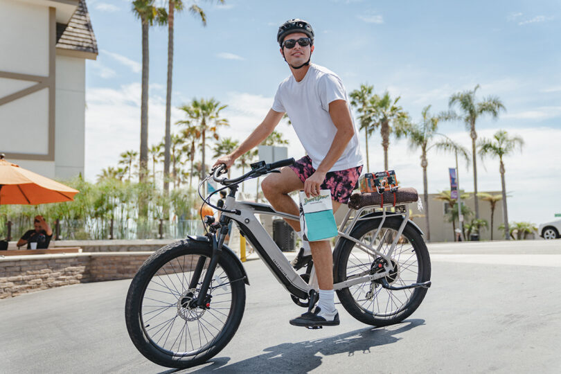 light-skinned man riding a cream colored e-bike