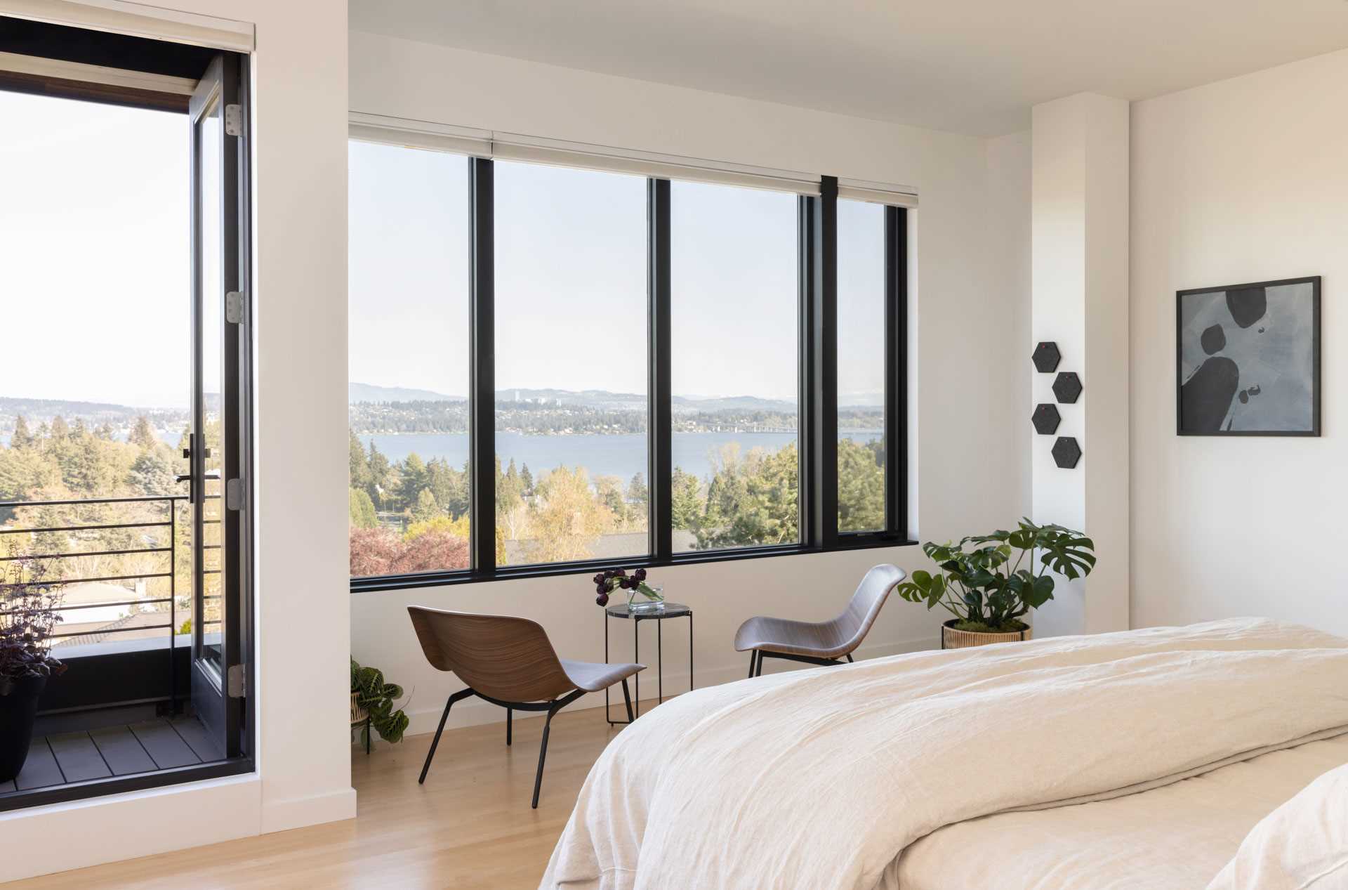 This primary bedroom was relocated from the basement to a newly added third story. Black-framed windows allow for a picturesque view.