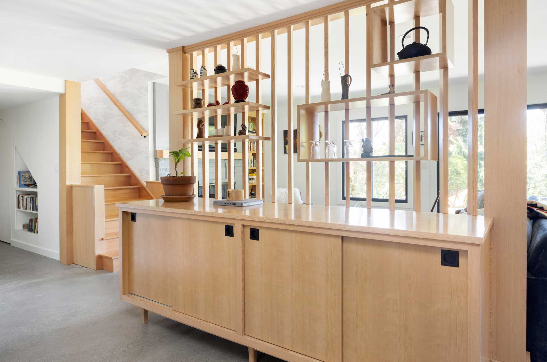 Wood slats and cabinets are used to create a divider in this family room.
