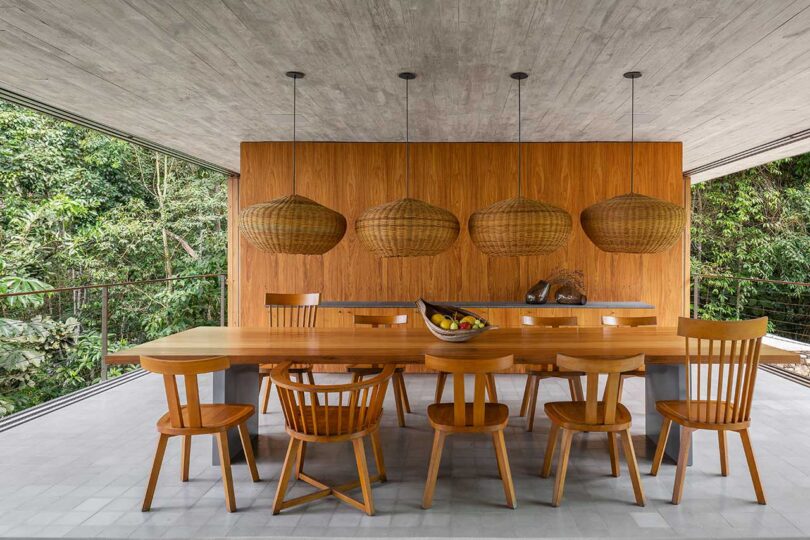 interior view of modern dining room with wooden table and chairs and partial wooden wall behind