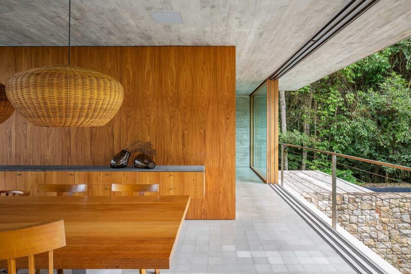 partial view of modern dining room with outer hallway leading to rest of house