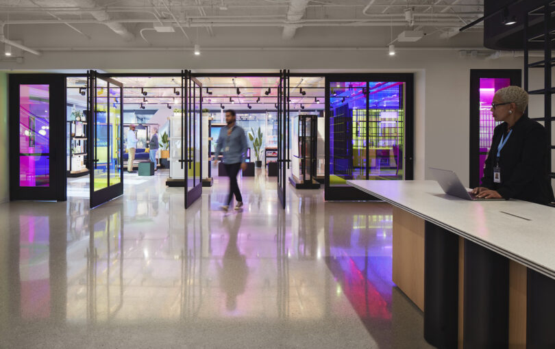 man walking through glass doors in modern office