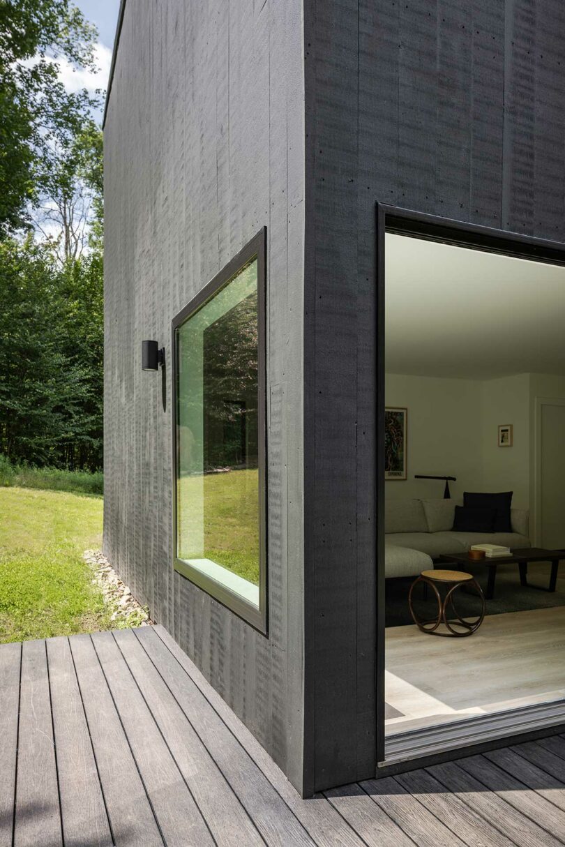 closeup view of modern black box house surrounded by trees