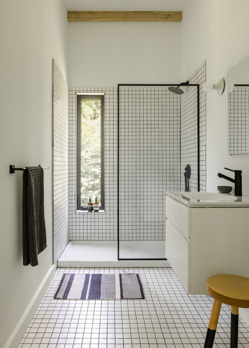 view of modern minimalist bathroom with white tiles and black grout