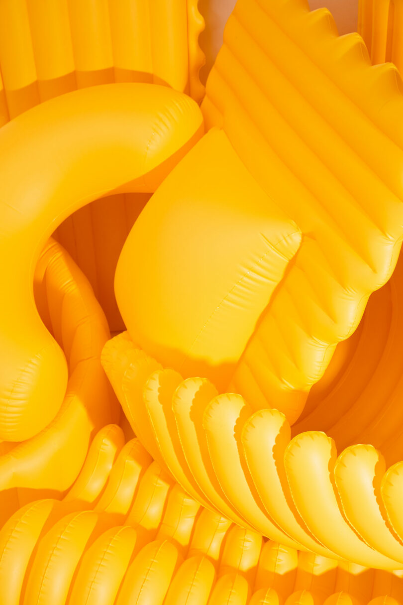 closeup of a bunch of yellow oversized pool floats shaped like pasta