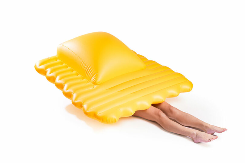 large yellow ravioli-shaped pool float with person's legs sticking out from under