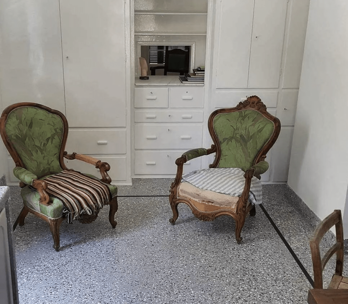 terrazzo floor in sitting room with two antique chairs