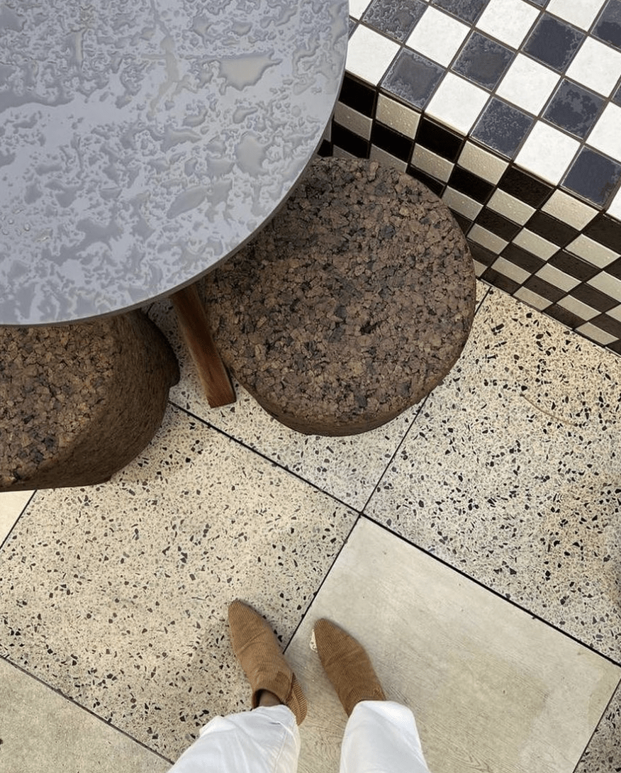 woman's feet in boots on terrazzo floor with checker bench