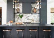 Modern kitchen design features a black oak island with black waterfall edge and wooden and metal tractor stools