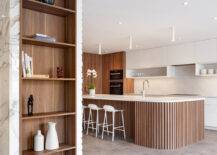 large mid century modern kitchen, featuring an open concept with an island and a wooden set of shelves.