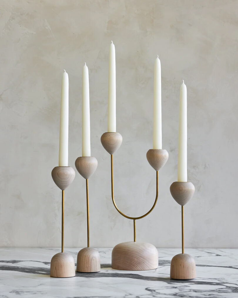 four modern light wood candle holders with white tapers