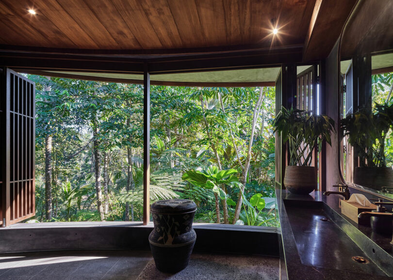 bathroom interior looking out big windows to jungle