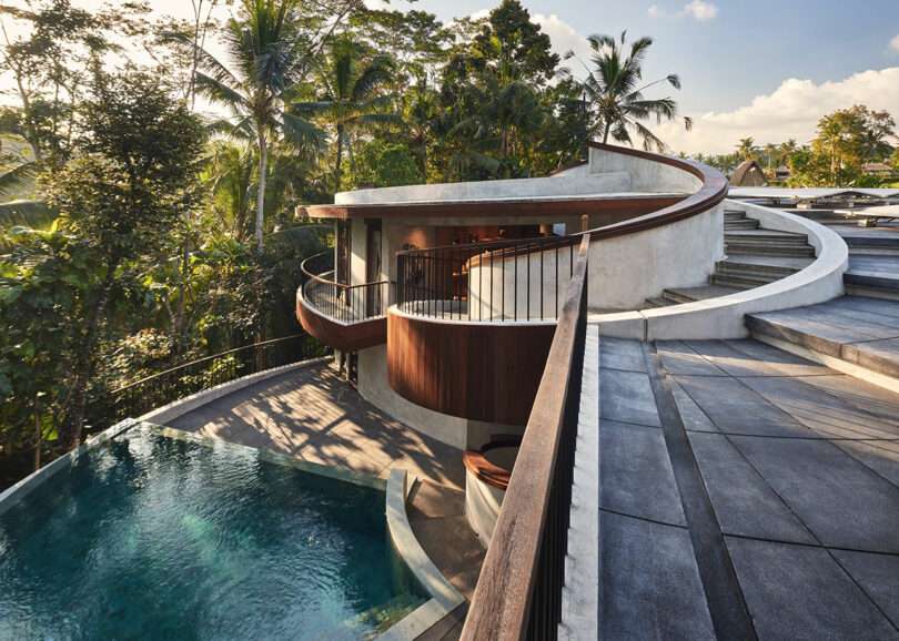 partial exterior view of modern house with spiral wood and concrete design with a pool