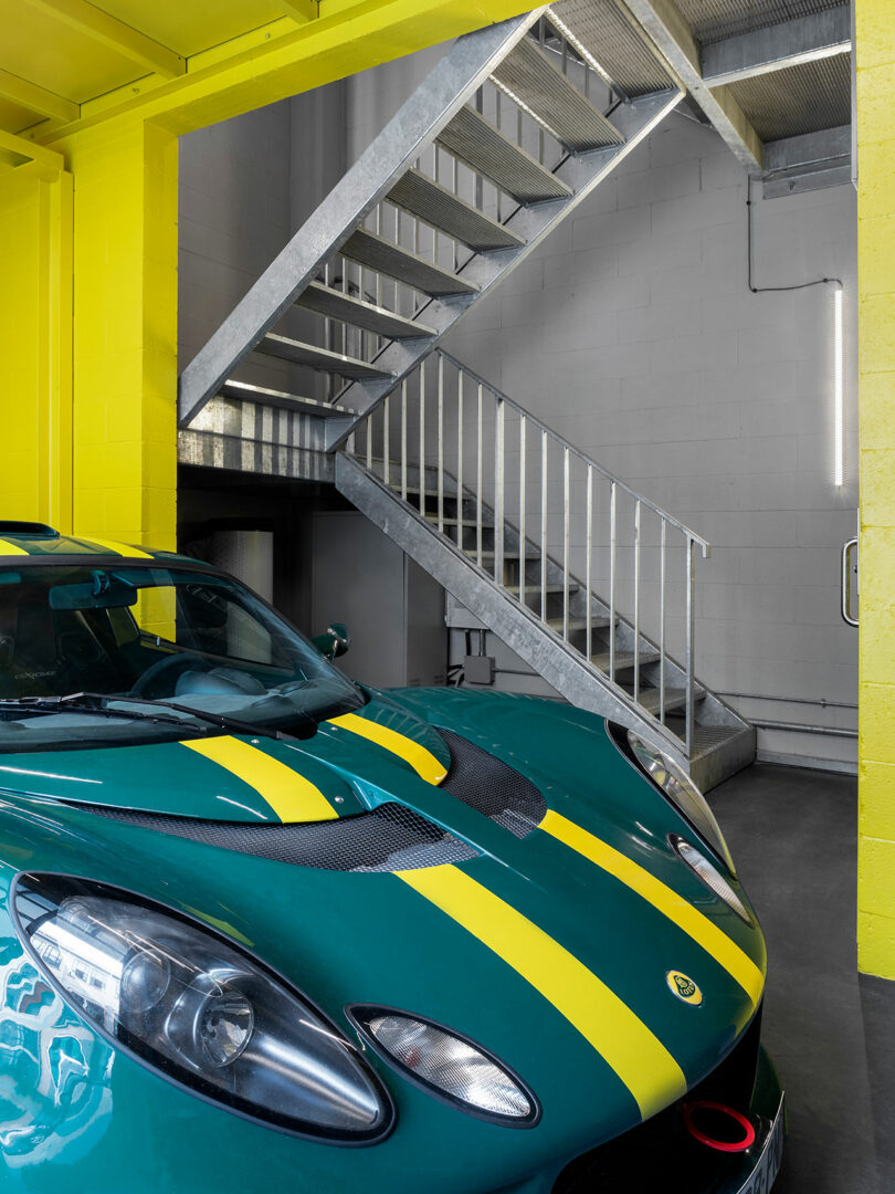 interior shot of modern industrial garage space with yellow details and green and yellow sports car parked