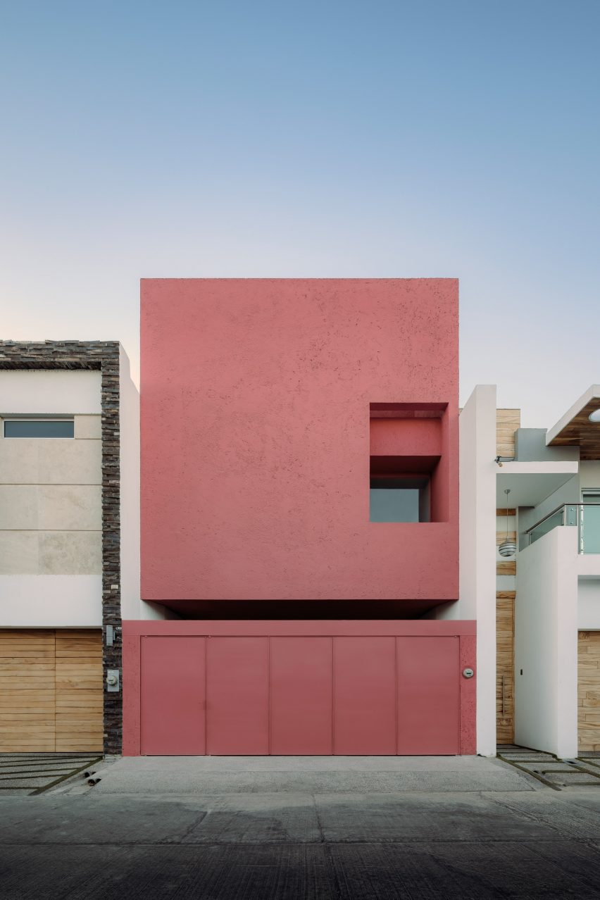 Street elevation of minimalist pink house between two white buildings