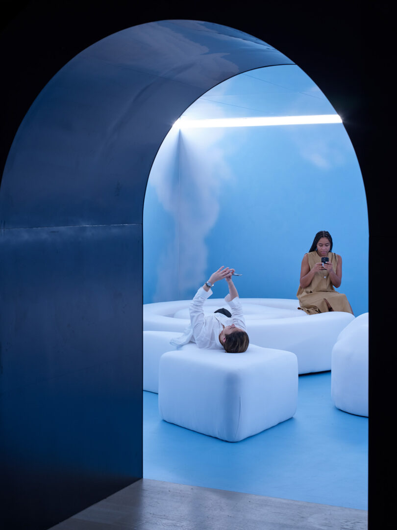 two people in a room with large white clouds and blue sky