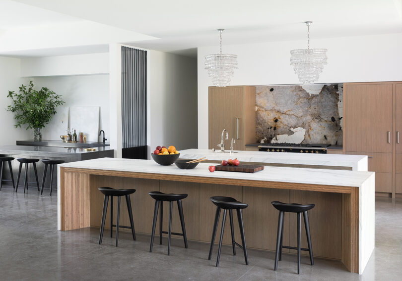 styled kitchen with large island and four modern stools