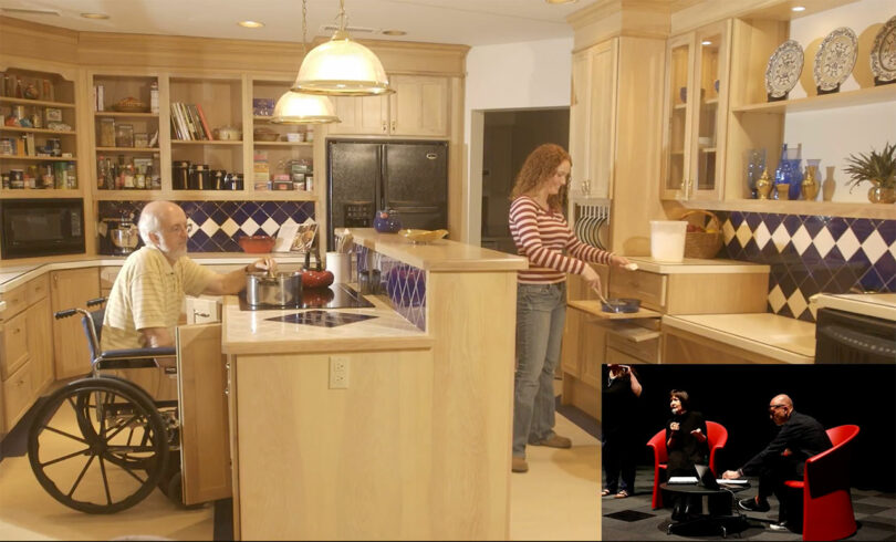 older image of wood kitchen with woman standing on lower cooktop and man in wheelchair pushed up to counter