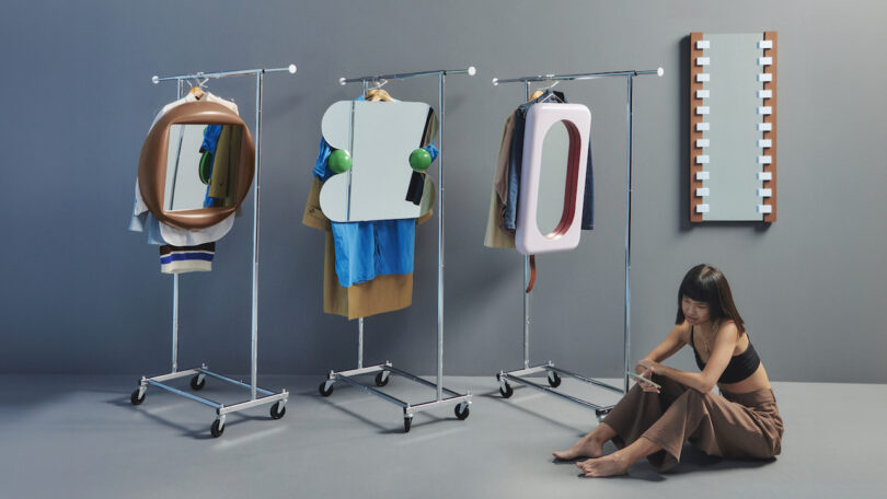 woman sitting on the ground next to four contemporary mirrors
