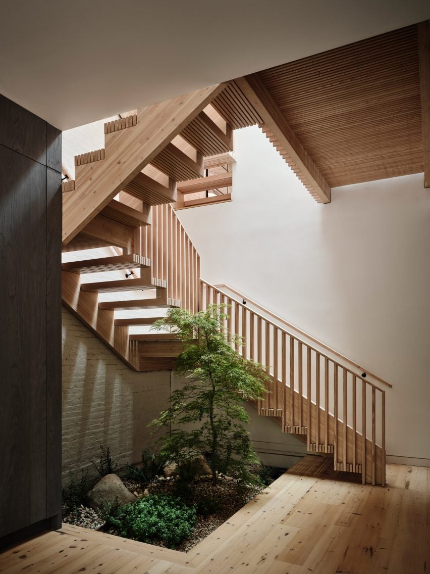 A wooden staircase with a planting bed at the base