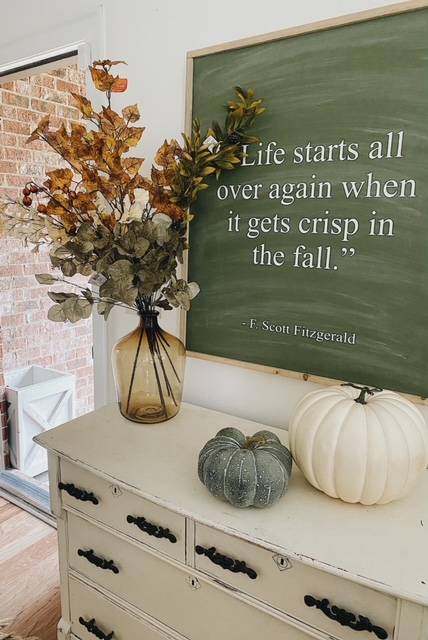 Simple fall entryway decor with pumpkins and large quote about fall.