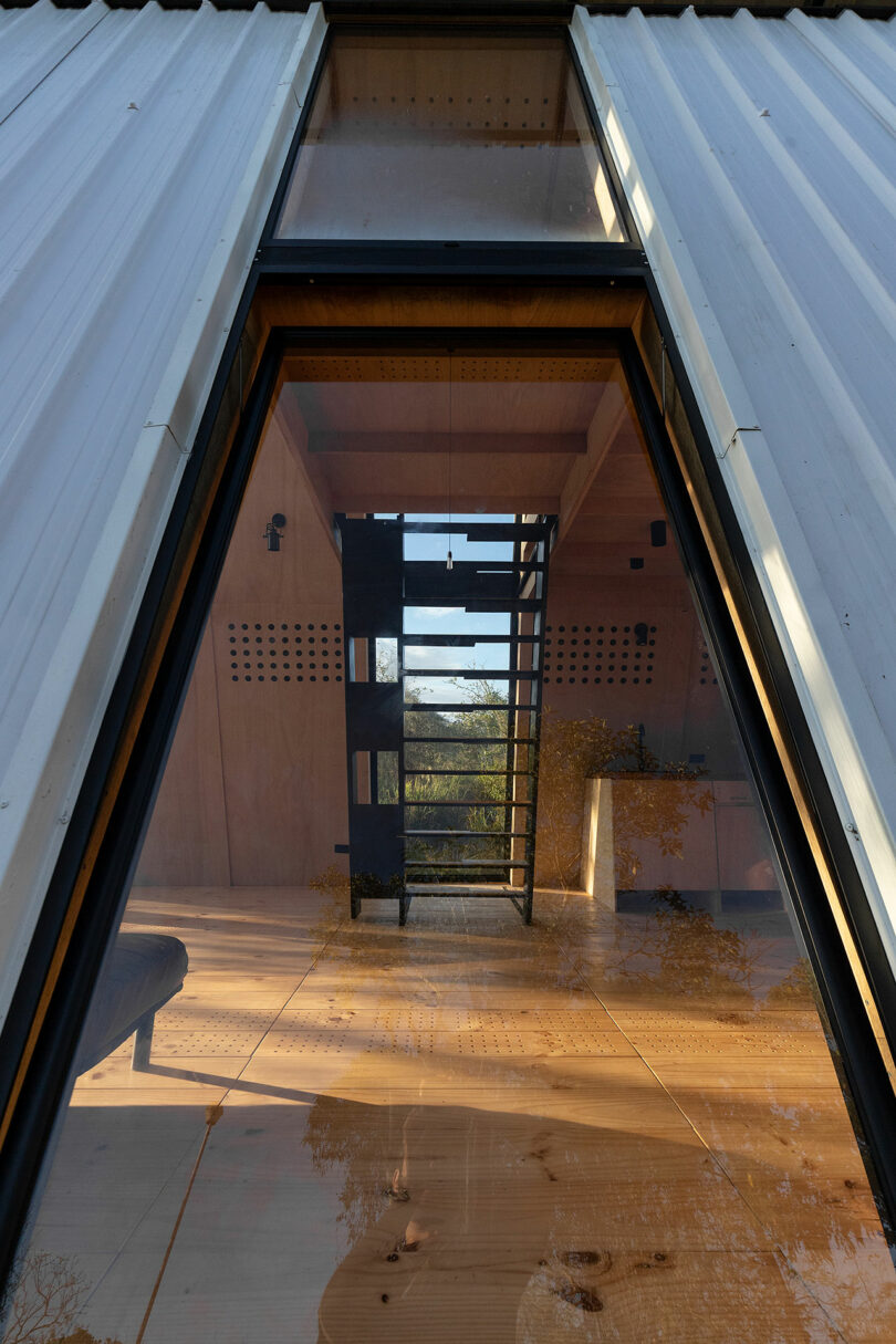 exterior view of tin roof a-frame cabin in woods