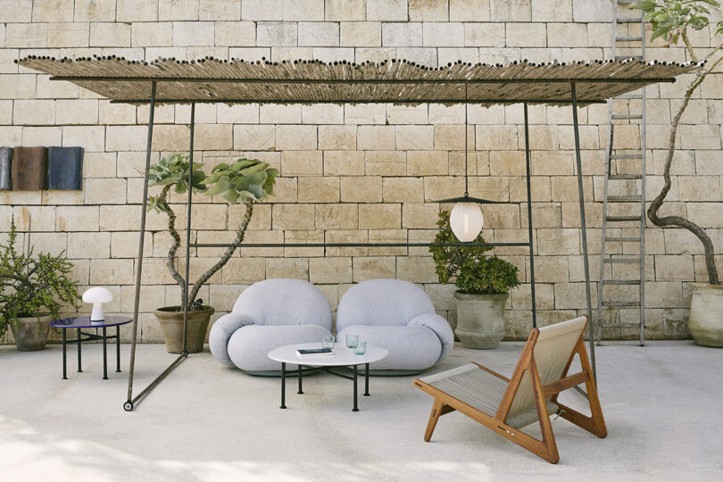 covered outdoor space with a sofa, armchair, and hanging light fixture