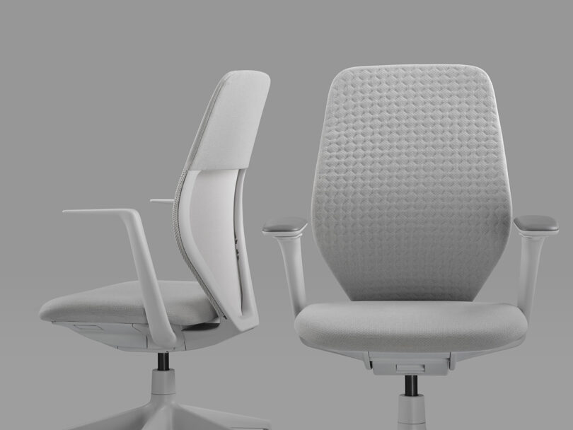 Two light gray Vitra ACX task chairs with arms, one on left facing toward the left, the second facing forward revealing its knit pattern cover back upholstery.