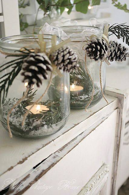 glass jars with candles greenery faux snow and pinecones
