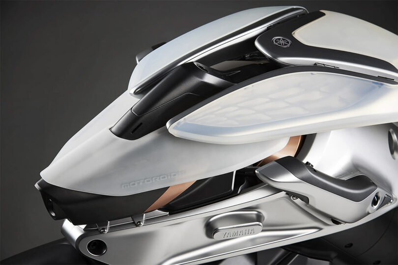 Close up of MOTOROiD 2's handle grips closely  positioned underneath the semi-transparent layered front fairing.
