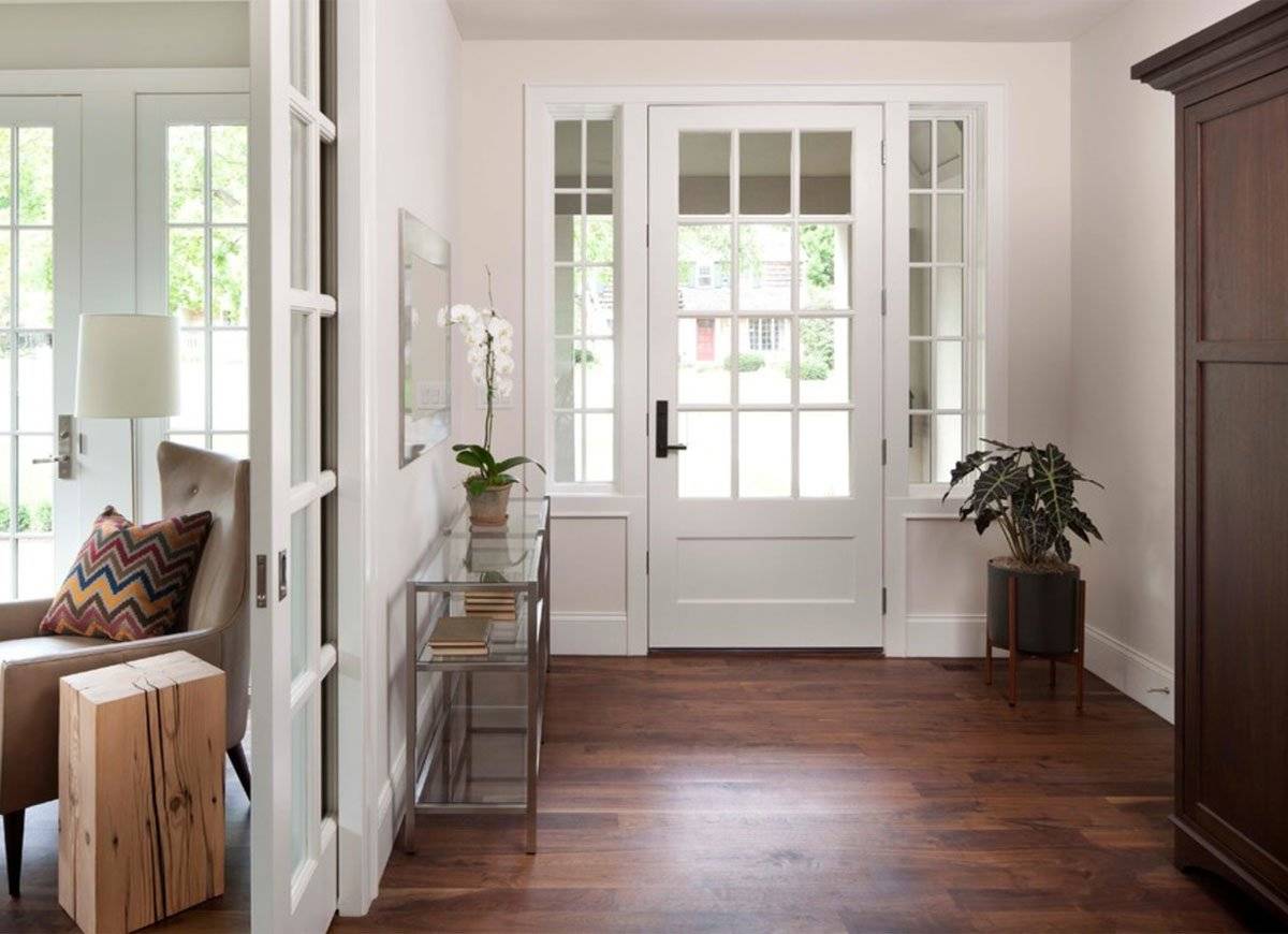Entryway with a white door and a glass/metal rectangular table with a plant on top.