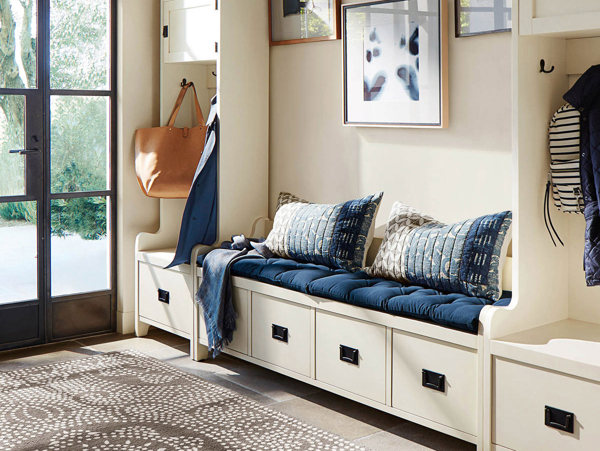 Modern entryway with a running and a bench that has blue cushions and pillows.