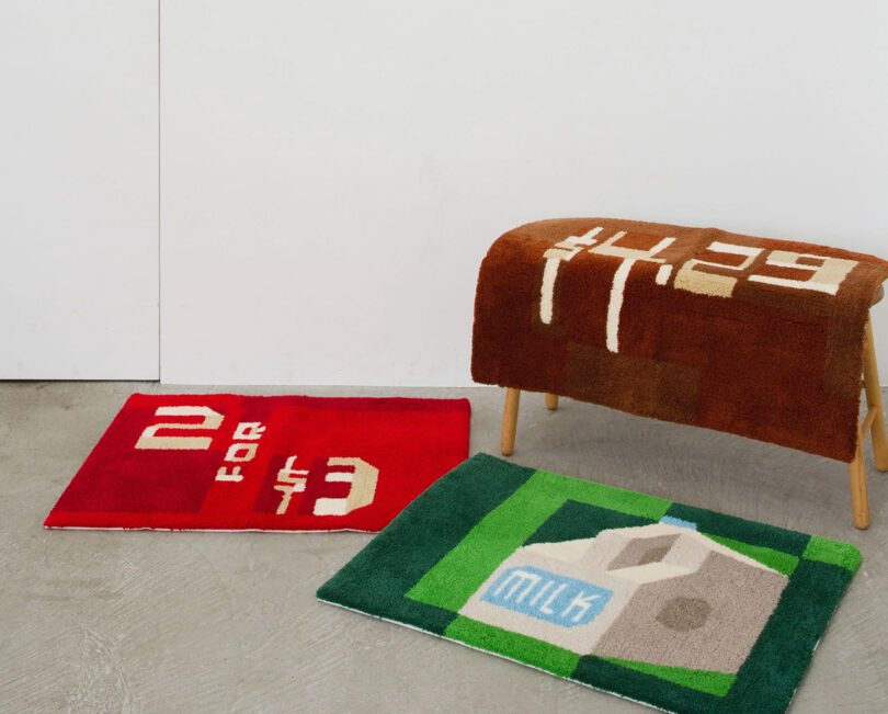 Three hand embroidered graphical rugs inspired by hand painted signage, including one that says "2 for $3", "$4.29" and a milk carton graphic.