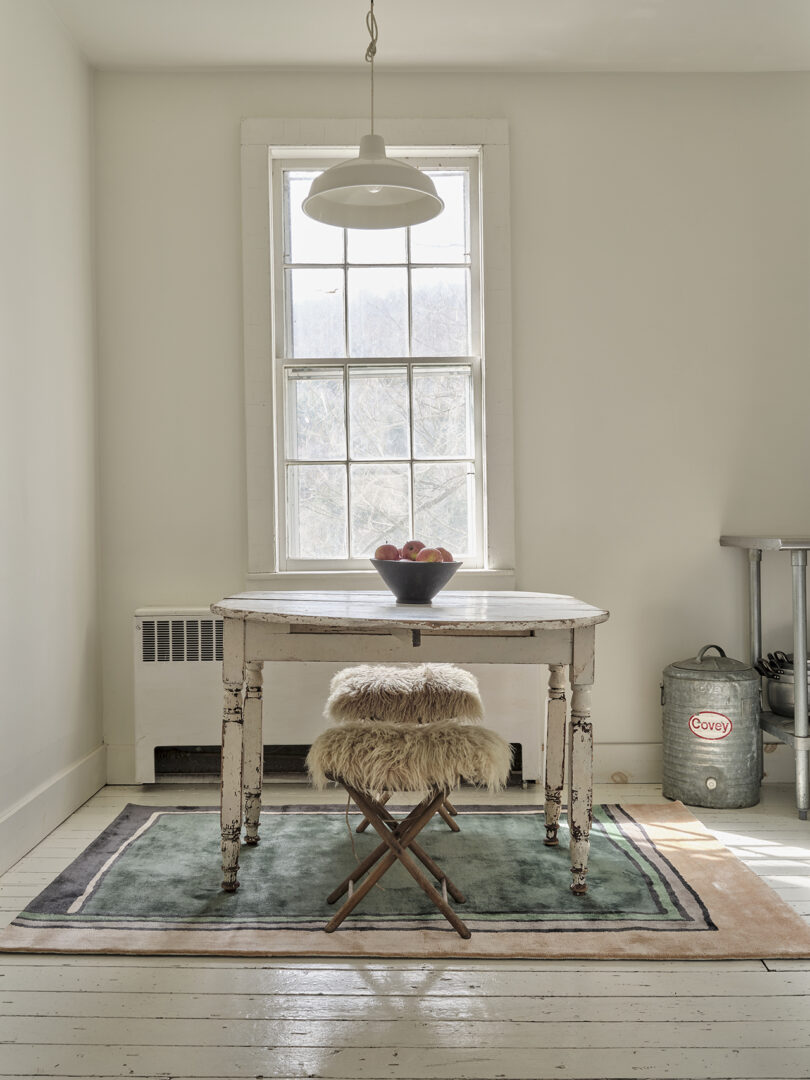 kitchen table and two stools on top of an abstract rectangular rug