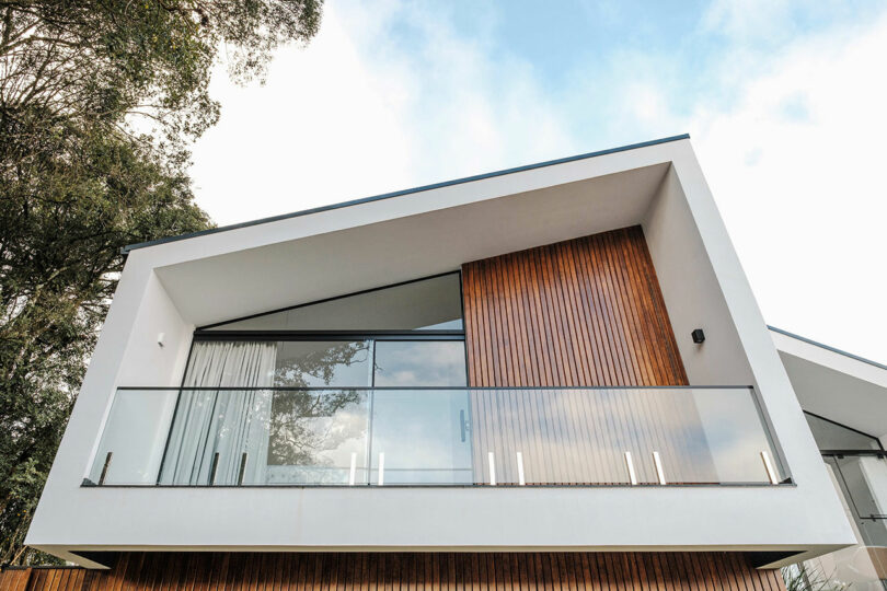 closeup up view of modern home with angular exterior with vertical wood slat cladding and gray details