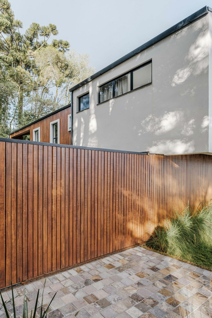 partial end view of modern home with angular exterior with vertical wood slat cladding and gray details