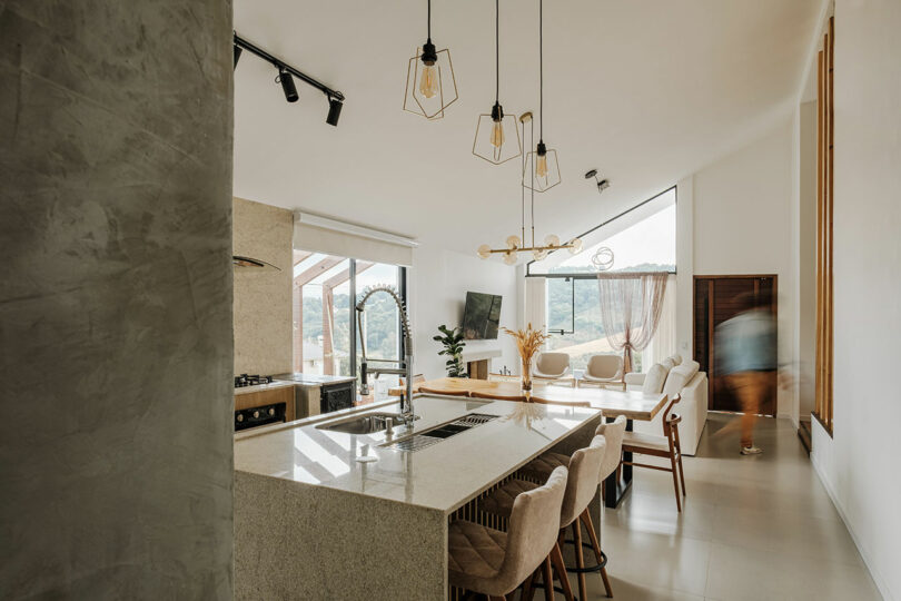 interior view of open modern living space with kitchen and living room under angled ceiling