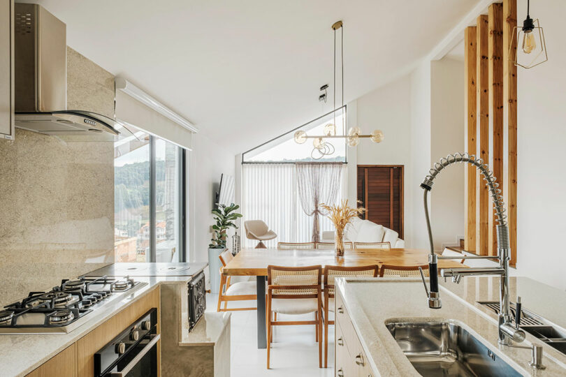 interior view of open modern living space with kitchen and living room under angled ceiling