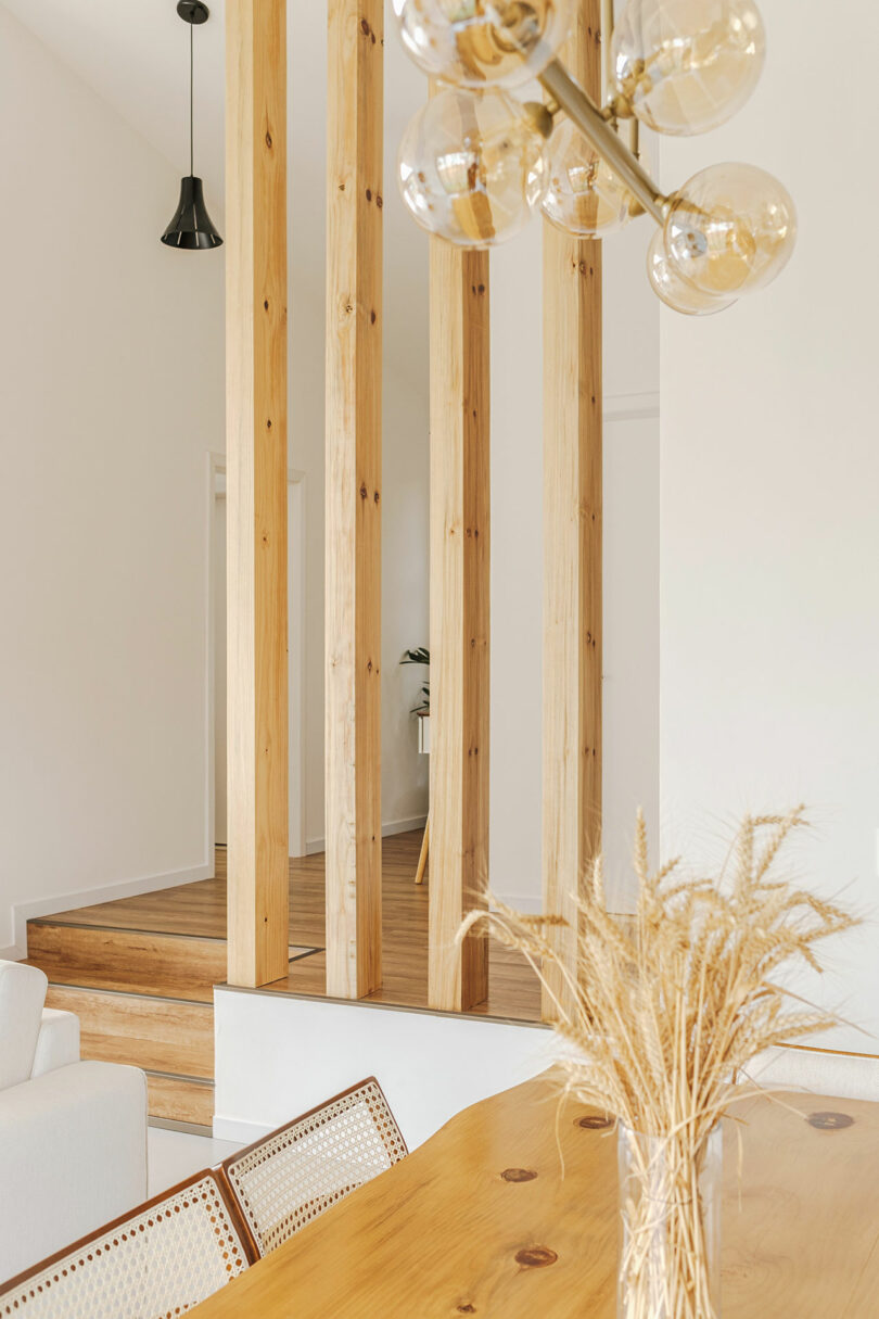 tight interior shot looking over dining table to vertical wood slat partition