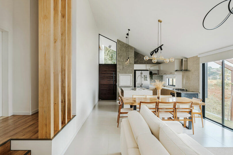 long interior view of modern open living space with living room, dining room, and kitchen