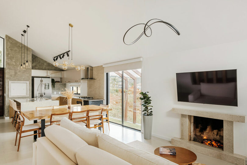 long interior view of modern open living space with living room, dining room, and kitchen