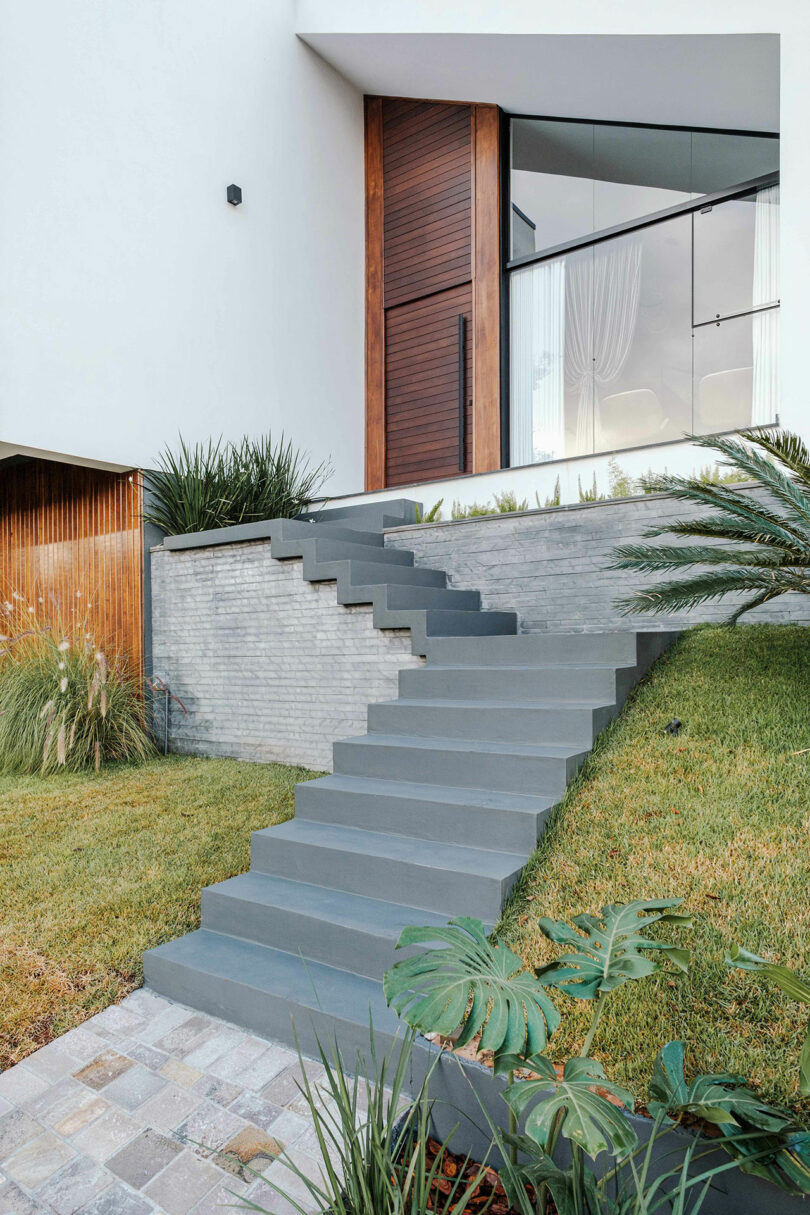 closeup partial view of modern home with angular exterior with vertical wood slat cladding and gray details