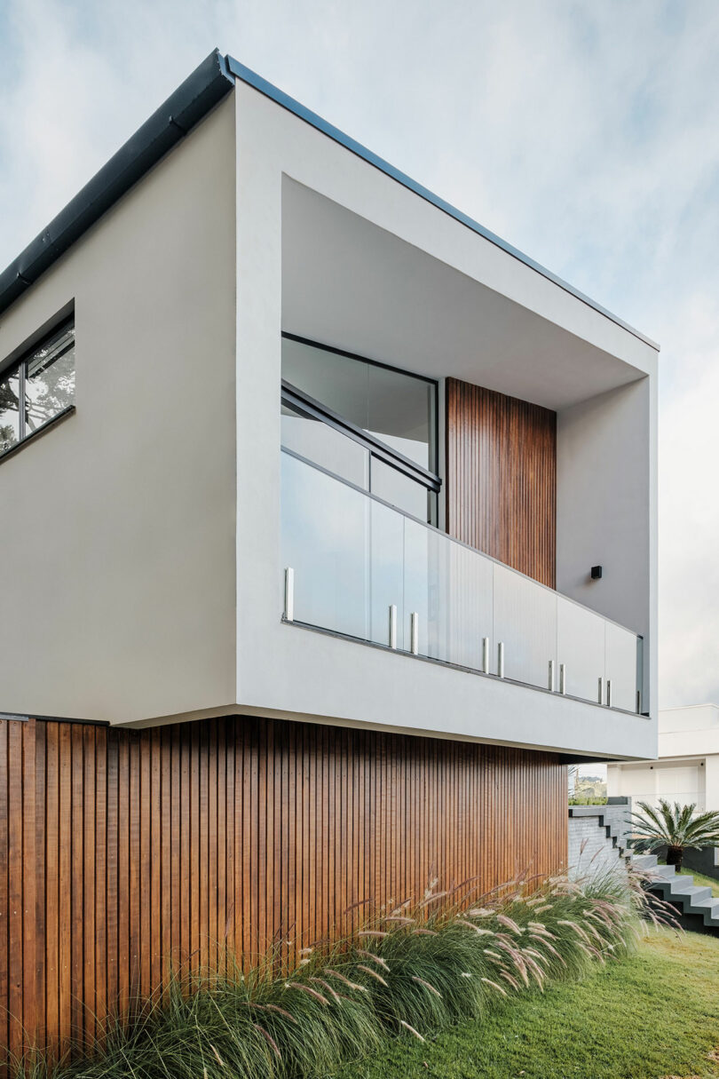 closeup partial view of modern home with angular exterior with vertical wood slat cladding and gray details