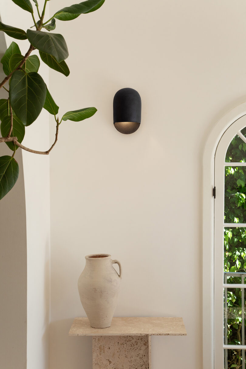 black domed ceramic sconce hanging on an interior wall of a home