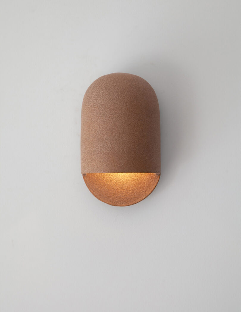 terracotta domed ceramic sconces hanging on a white wall